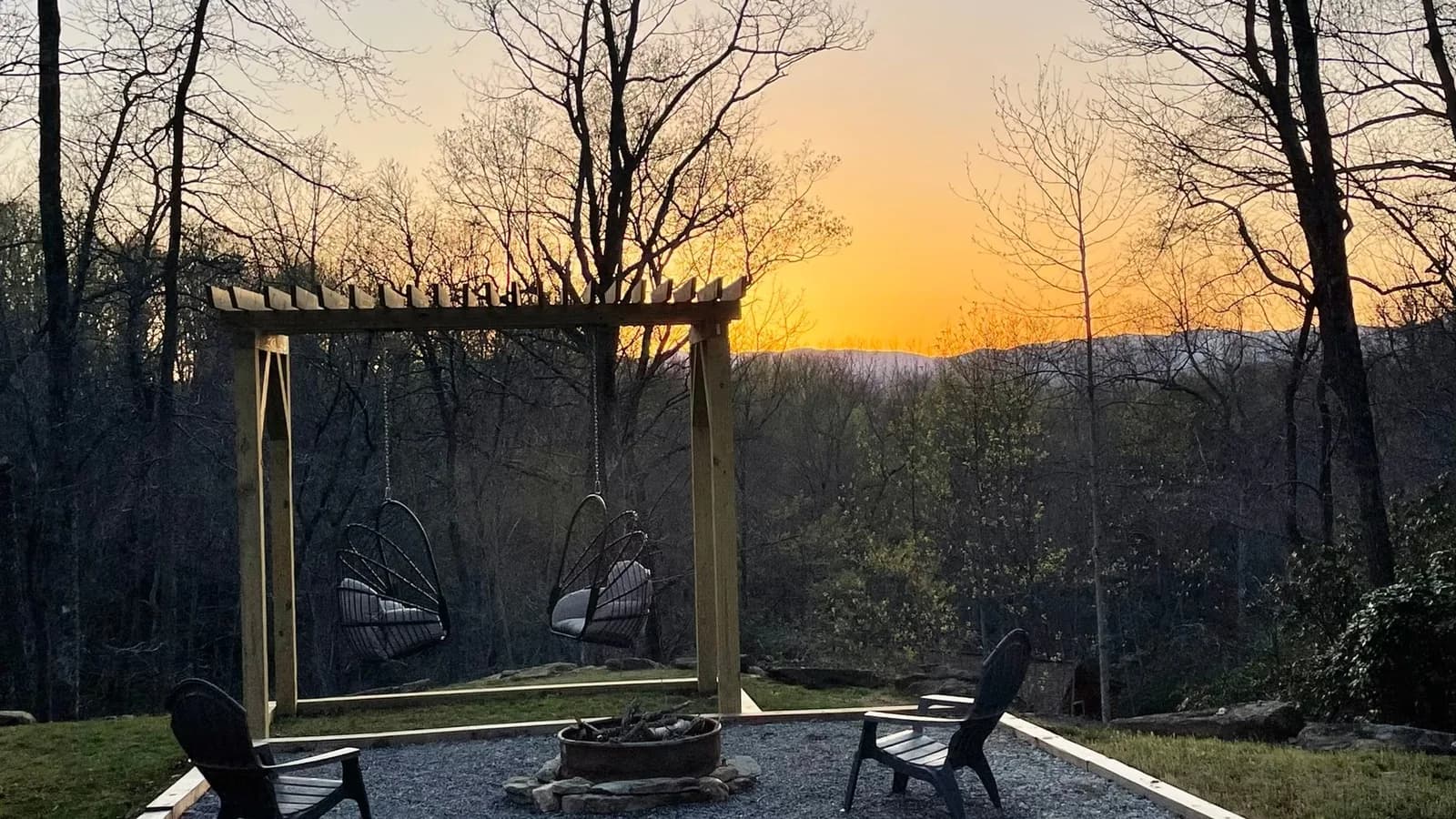 Whispering Trees Loft pergola swings at sunset