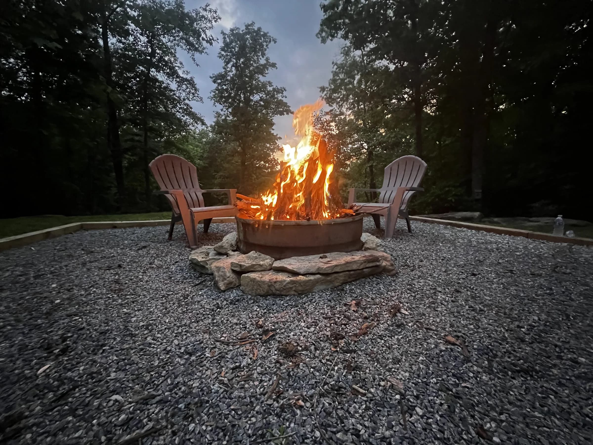 Whispering Trees Loft fire pit glowing at dusk