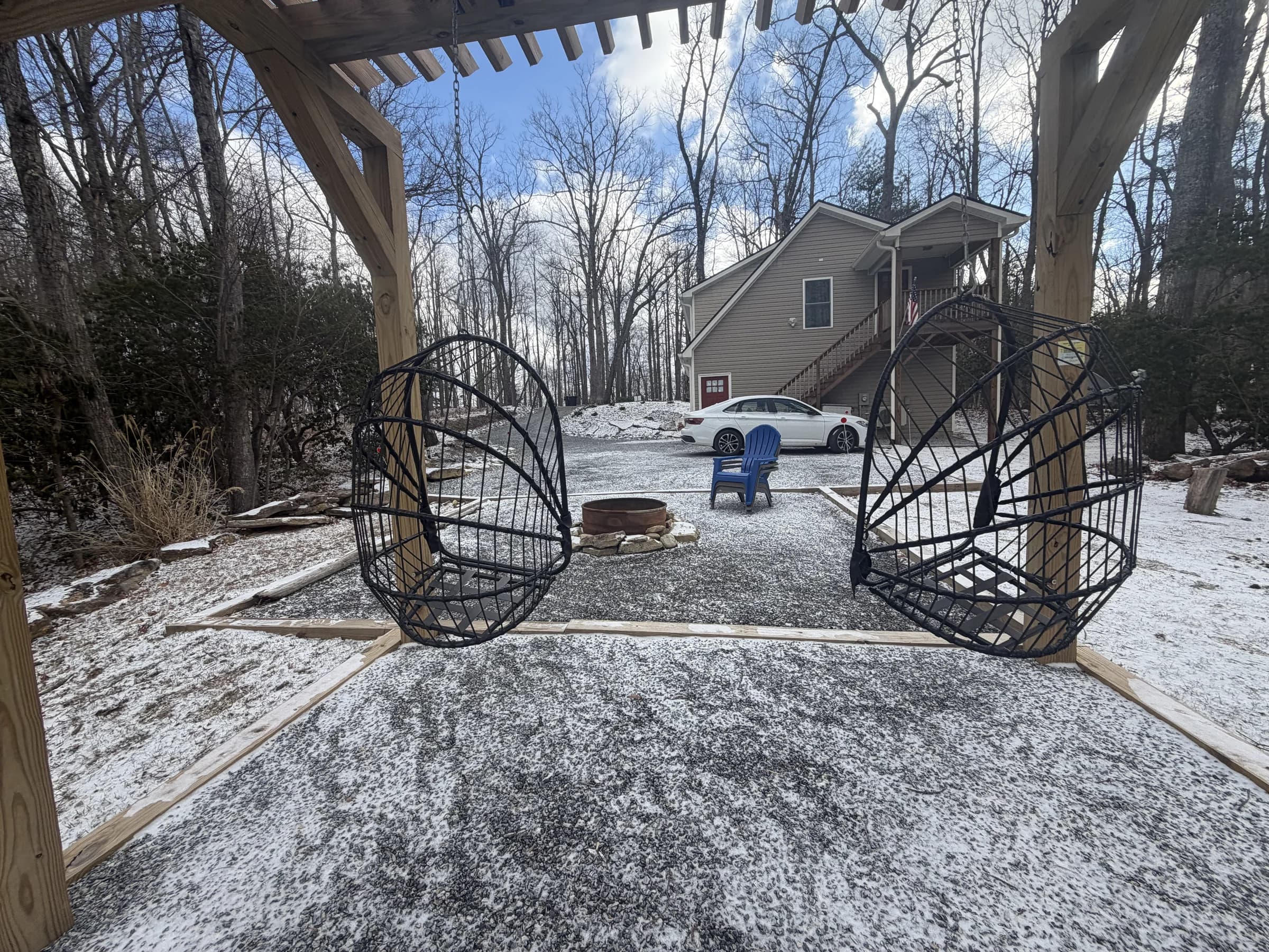 Whispering Trees Loft pergola swings in the wooded yard